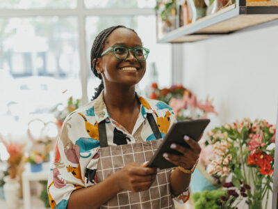 Young shopkeeper in an apron in a floral shop
