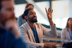 Man in seminar with hand raised