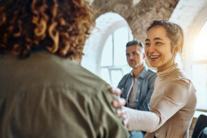 Woman putting her hand on another woman's shoulder in greetings