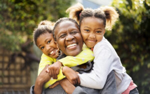 Image of grandmother with grandchildren smiling