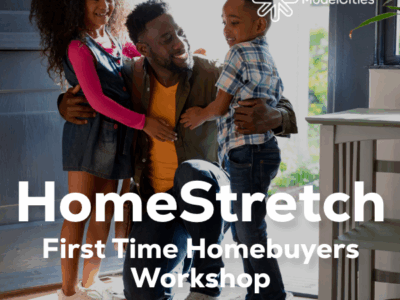 Parent with two school age children, smiling while in the doorway of their home