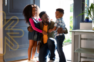 Photo of parent and school age children smiling in the entryway to their home
